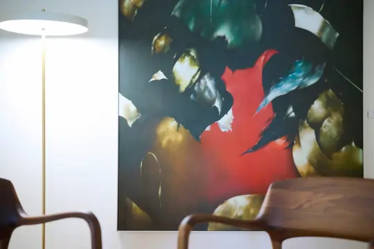 Nahausnahme eines Bildes mit dunklen Farben und sehr dominantem rot in der Mitte des Bildes.