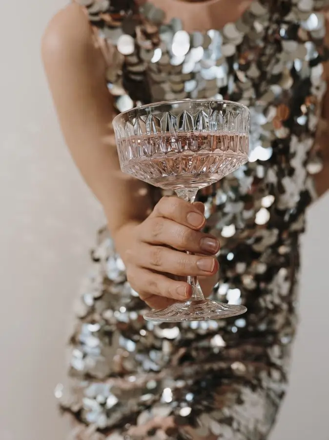 Eine Frau hält ein Glas in der Hand.